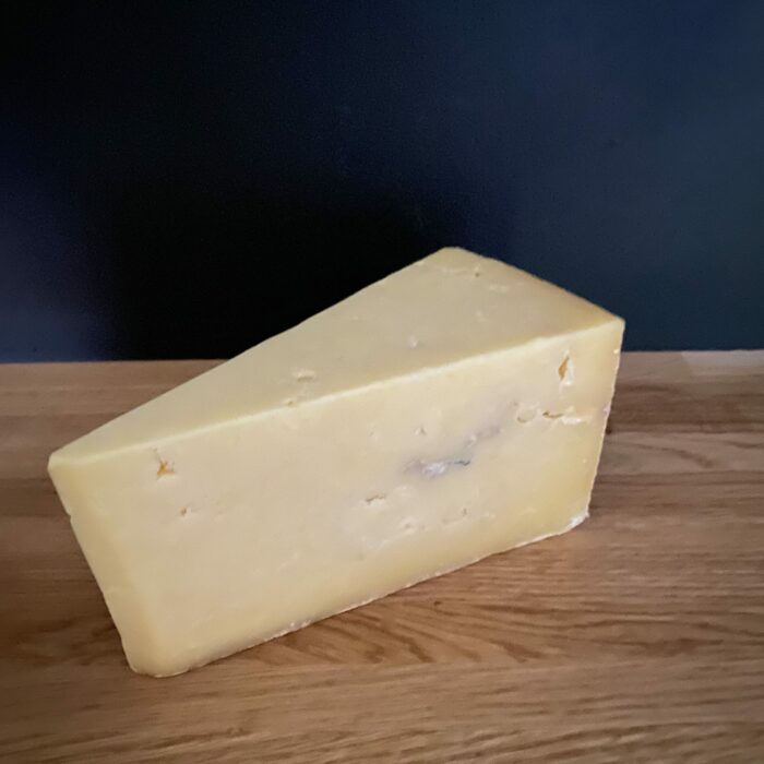 Keens Mature Cheddar larger wedge side view scaled 1